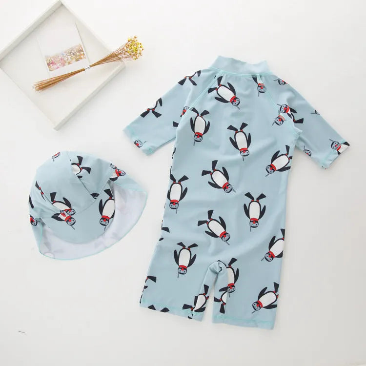 Boy's penguin print long sleeve swim shirt and matching cap set for sun protection.