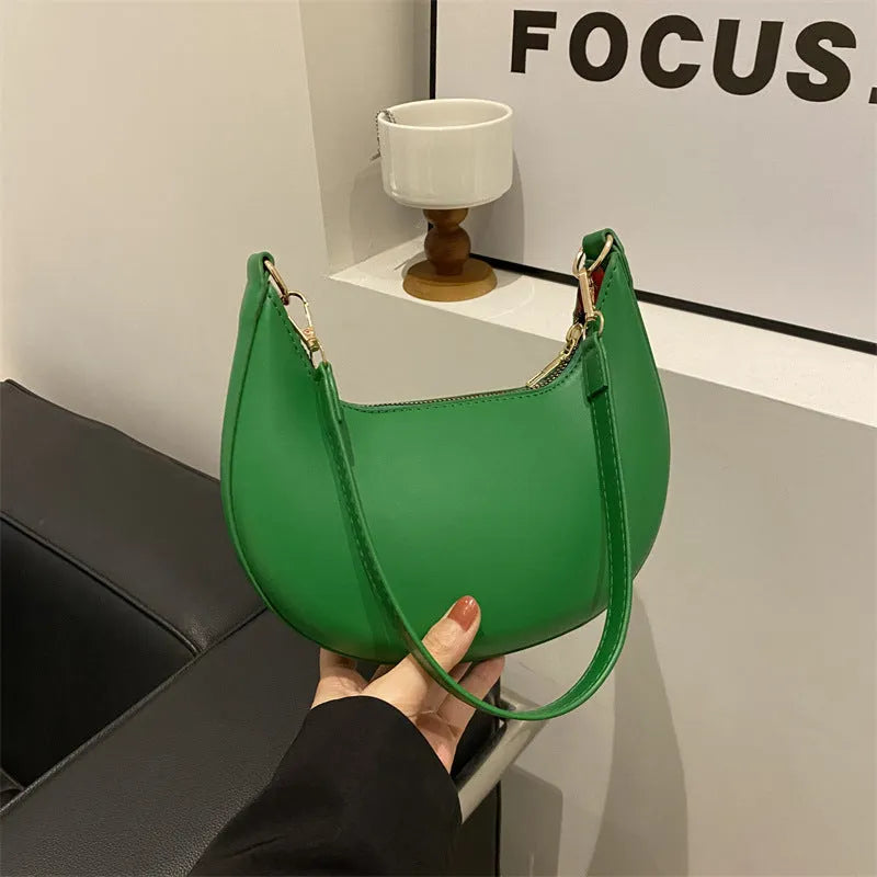 Round one-shoulder underarm bag in PU material, shown in green colour with visible sewing lines and a single strap.