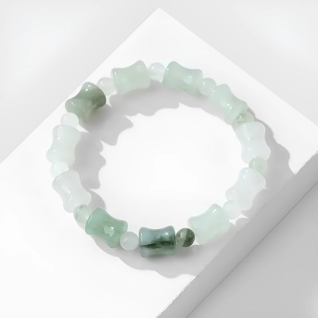 Simple beaded bracelet with a diamond-cut Tianshan Emerald chalcedony stone and coconut shell beads on an elastic band.