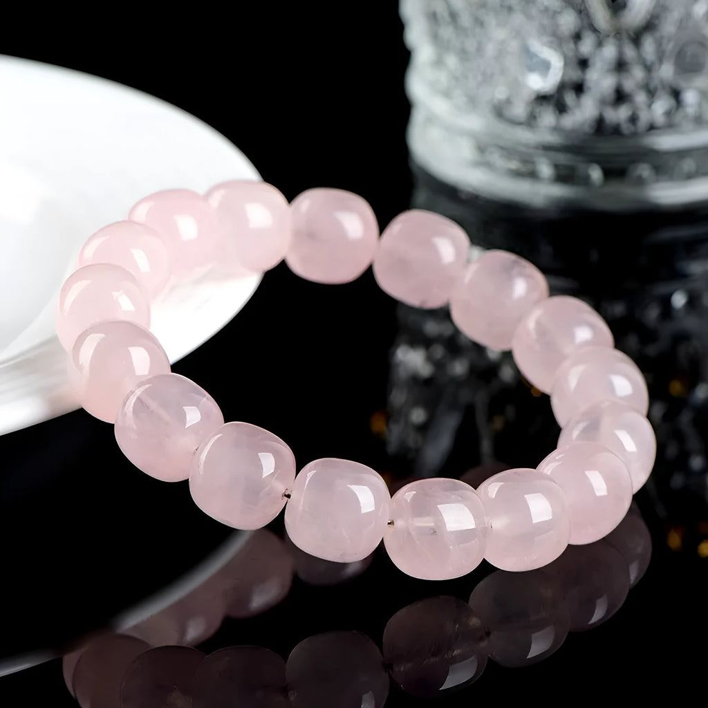 Pink crystal barrel bead bracelet with geometric beads on an elastic cord