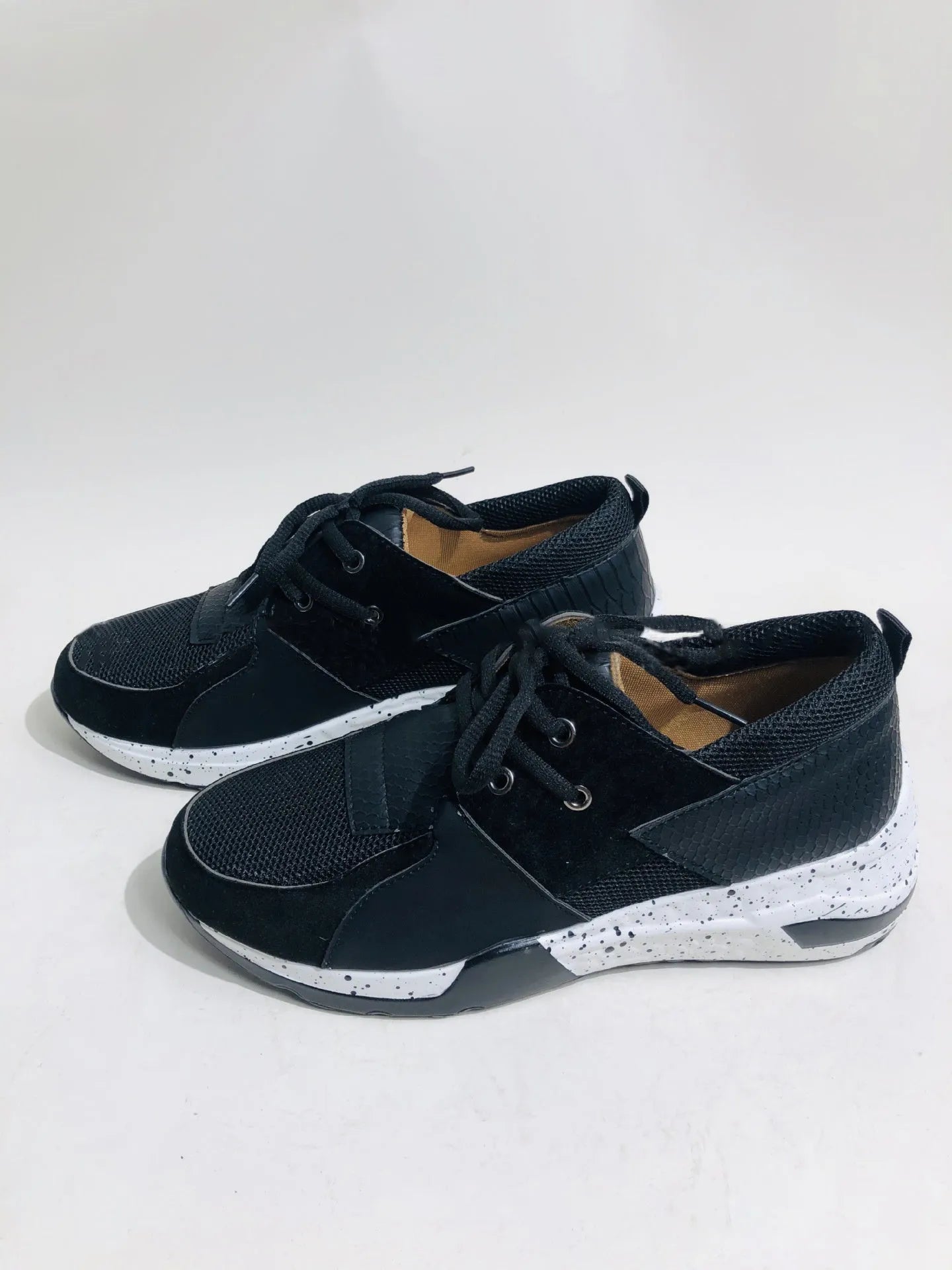 Women's suede sneakers with a wedge heel in leopard print, shown on a foot.