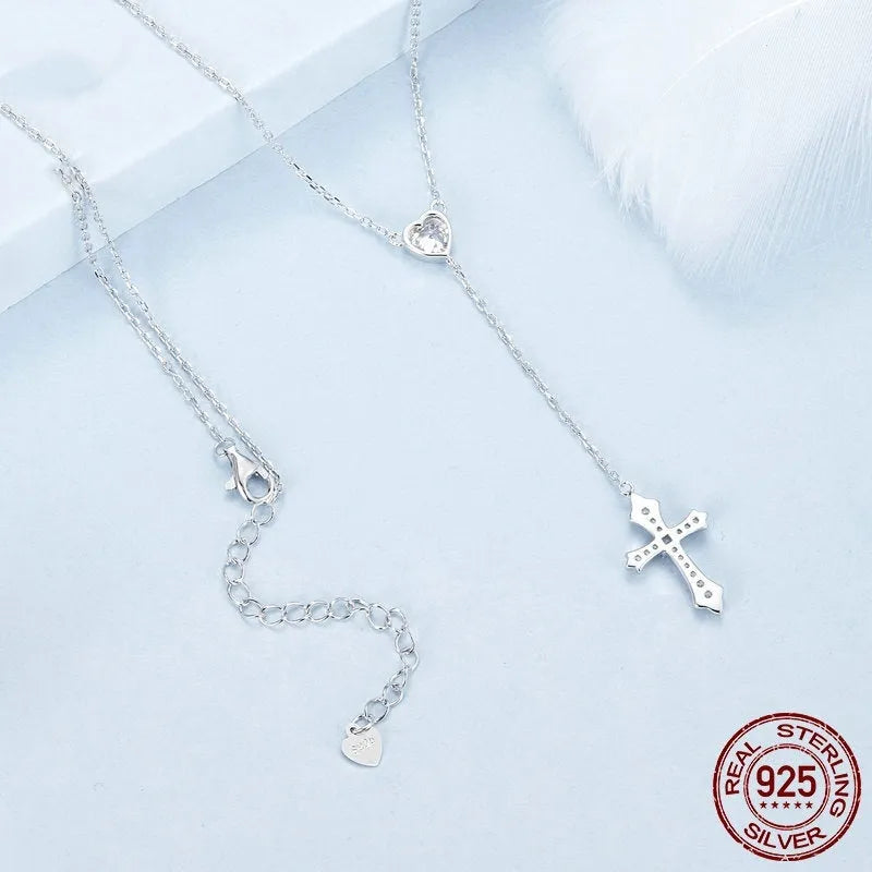 Simple silver love cross pendant necklace with O-ring chain on a V-neck.