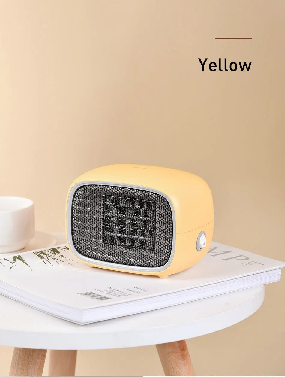 Small green portable ceramic fan heater on a desk showing its compact size.