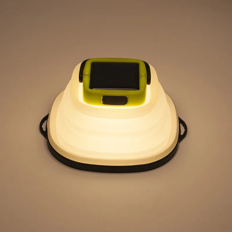 Green telescopic LED camping light folded and extended on a table with suction cup