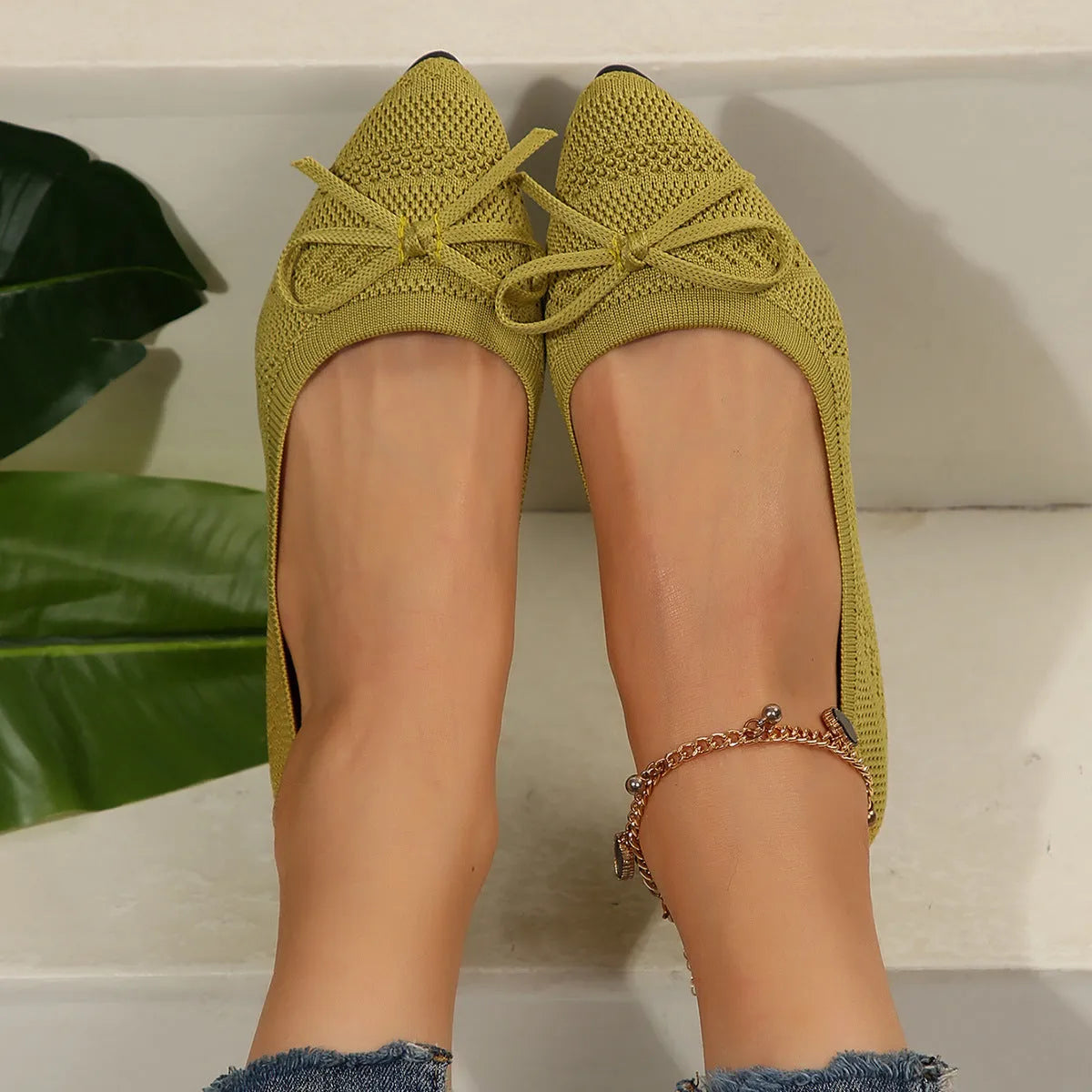 Women's blue knitted loafers with a bow detail and pointed toe on a flat rubber sole.