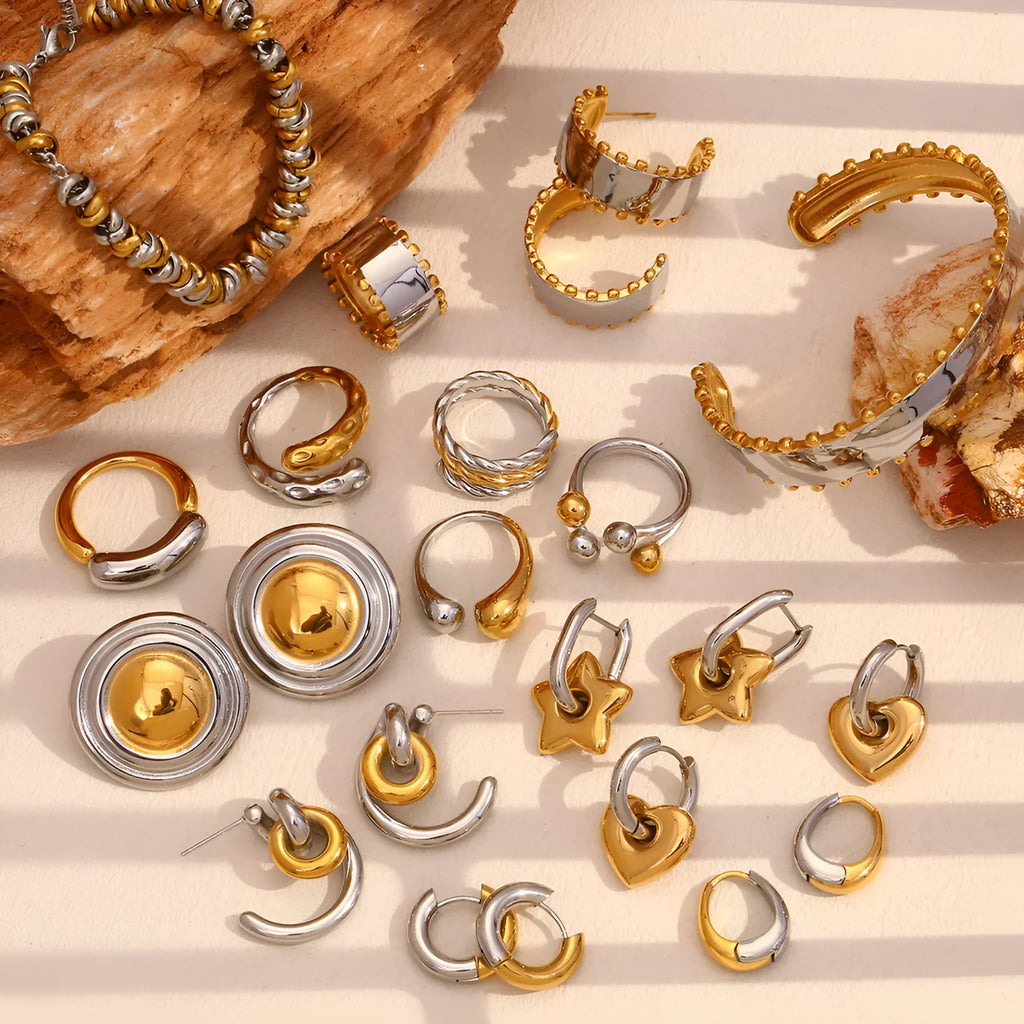Gold geometric women's jewellery set with earrings, bracelet, and necklace on a plain background