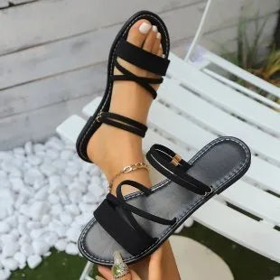Women's flat sandals with cross strap and flip-toe buckle in black, brown, or green colours