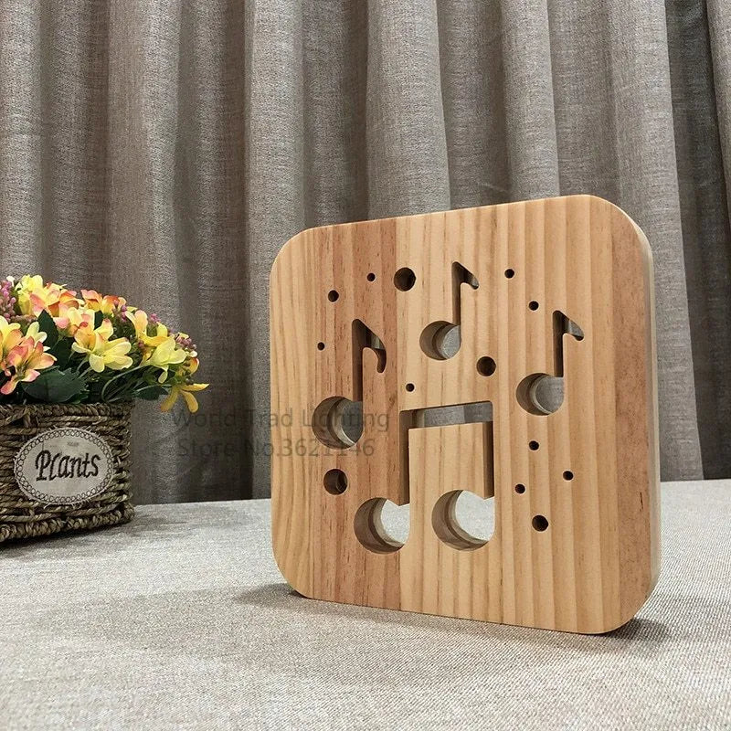 Square pine wood USB lamp with 3D design emitting warm white light on a wooden desk.