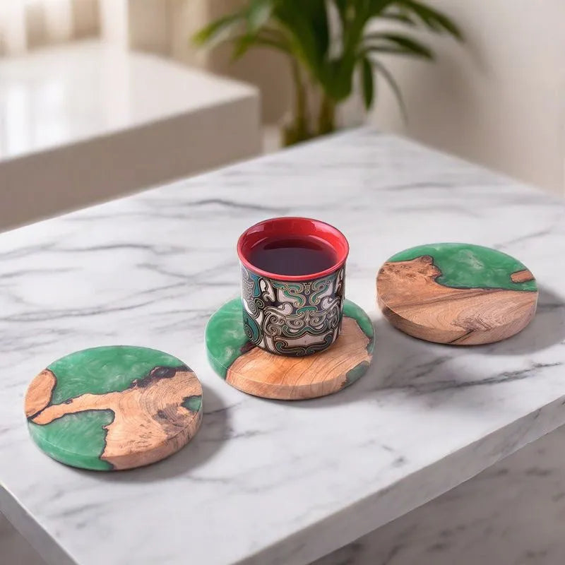 Set of solid wood coasters for tea, showing round green and black versions on a wooden table.