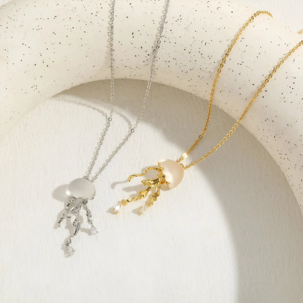 18K gold titanium steel openwork jellyfish pendant on silver O-ring chain against white background