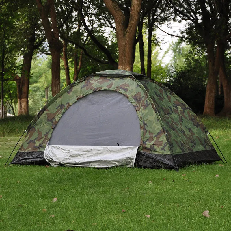 Green camouflage two-person tent with mesh windows, pitched outdoors.