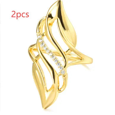 Gold coloured women's ring with an exaggerated curved design on a copper band.