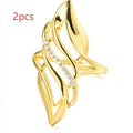 Gold coloured women's ring with an exaggerated curved design on a copper band.