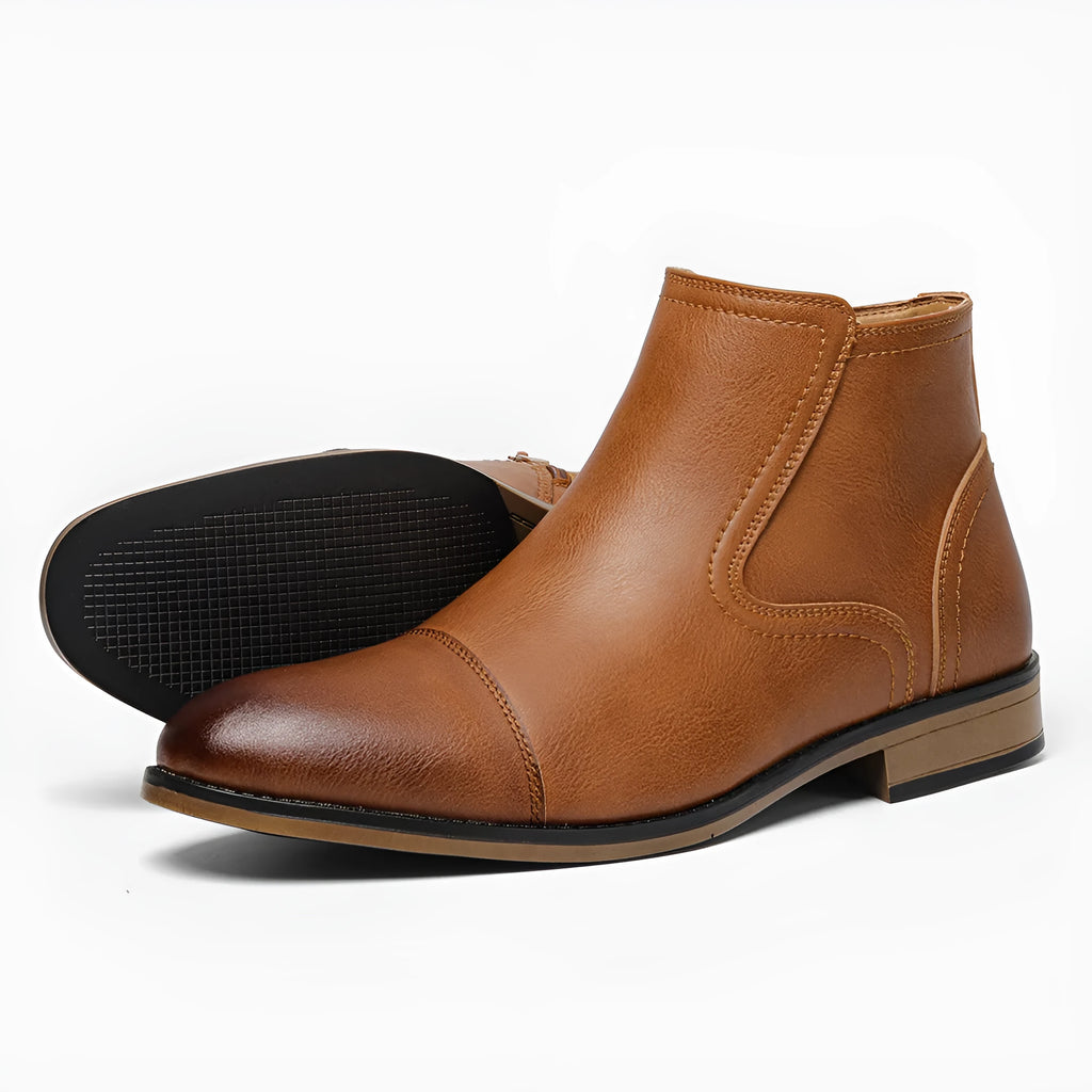 Men's brown Chelsea ankle boots with a visible side zipper on a wooden sole.