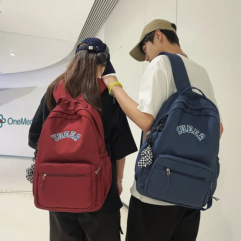 Simple nylon backpack for women, 32cm, with computer pocket, in five colours including black, blue, red, white, and light green.