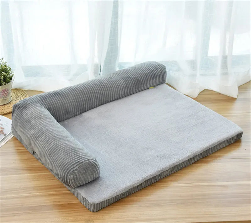 Large grey corduroy dog sofa bed with raised sides on a wooden floor