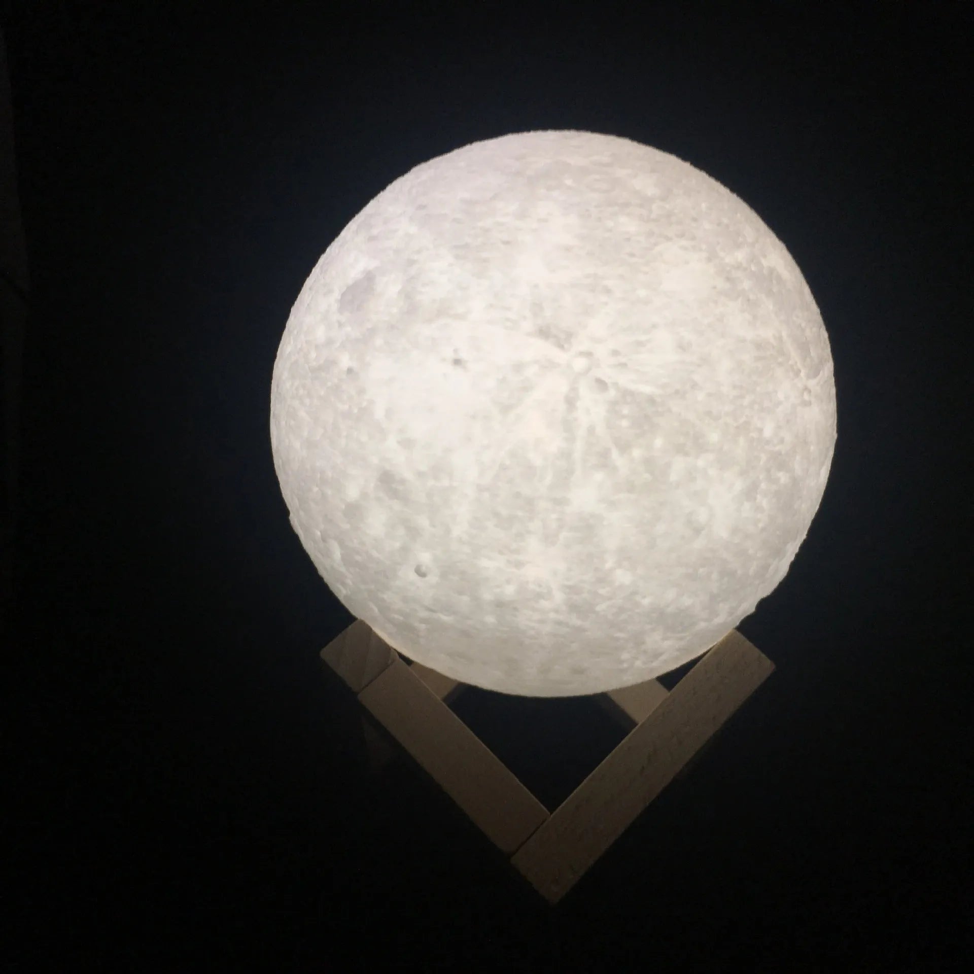 3D printed white moon lamp with detailed craters on a wooden holder, showing touch ring at base.