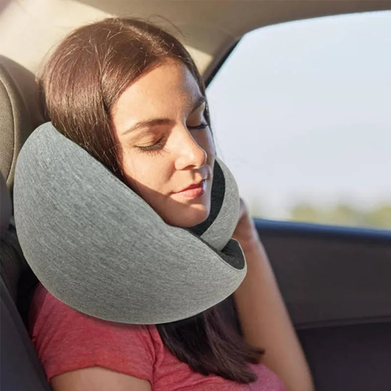 Navy blue memory foam U-shaped travel neck pillow rolled up next to its carry bag