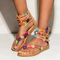Ethnic style beaded petal sandals with floral design and round toe on a white background.