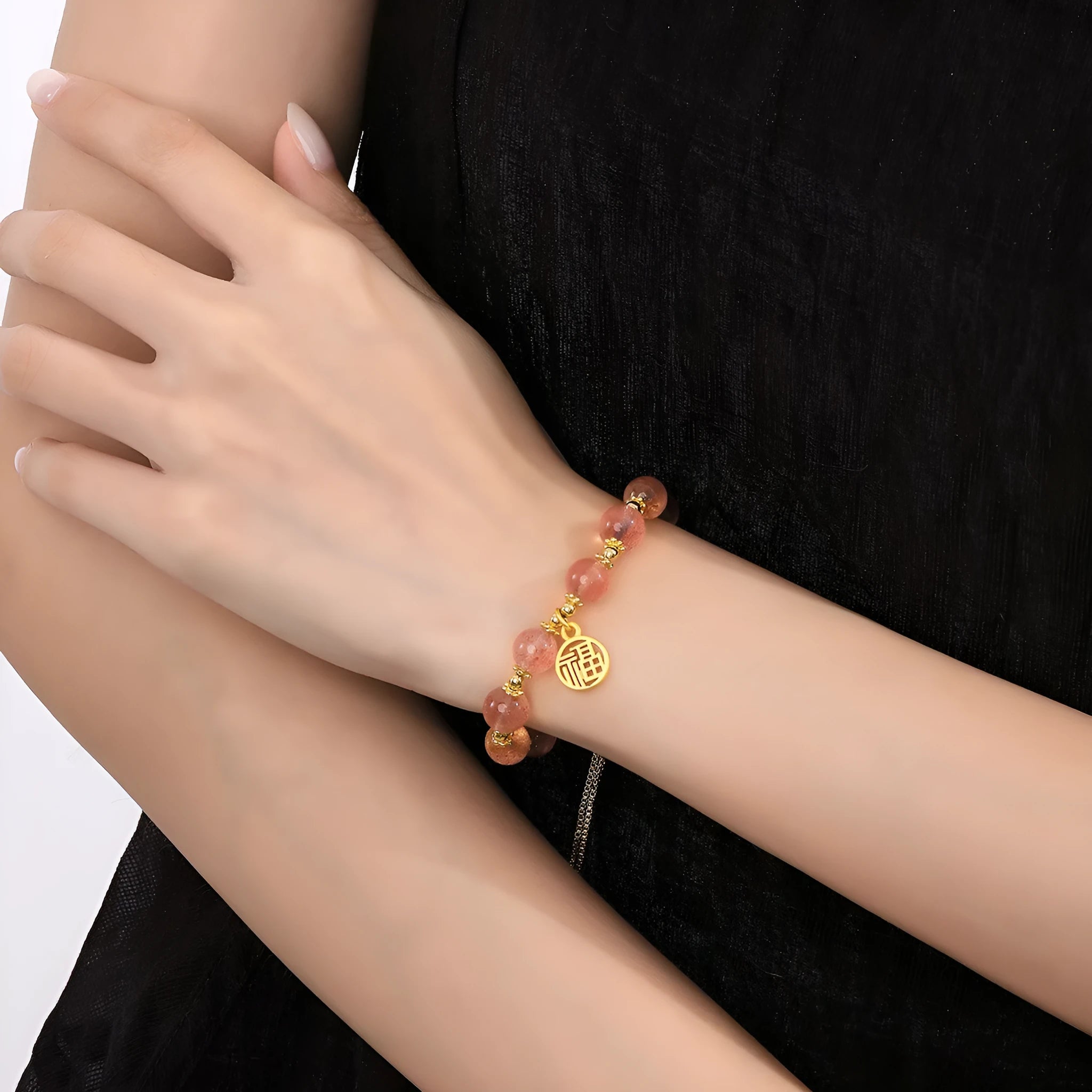 Women's strawberry quartz bracelet with a geometric fu character charm on an electroplated chain.