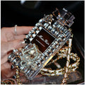 iPhone case with a perfume bottle and bow charm on a metal chain, in black colour with textured TPU shell.