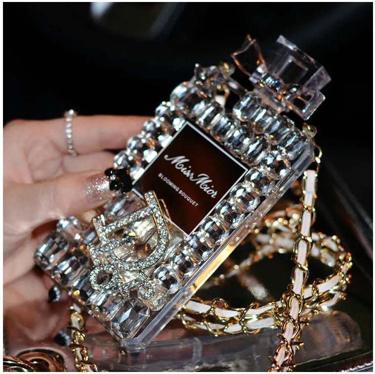 iPhone case with a perfume bottle and bow charm on a metal chain, in black colour with textured TPU shell.