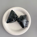 Girl's leather bow lazy bracket with transparent support in black, shown on a plain background