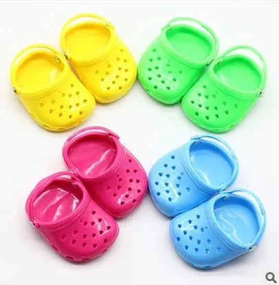 Plastic doll beach slippers in blue, red, yellow, and green colours.
