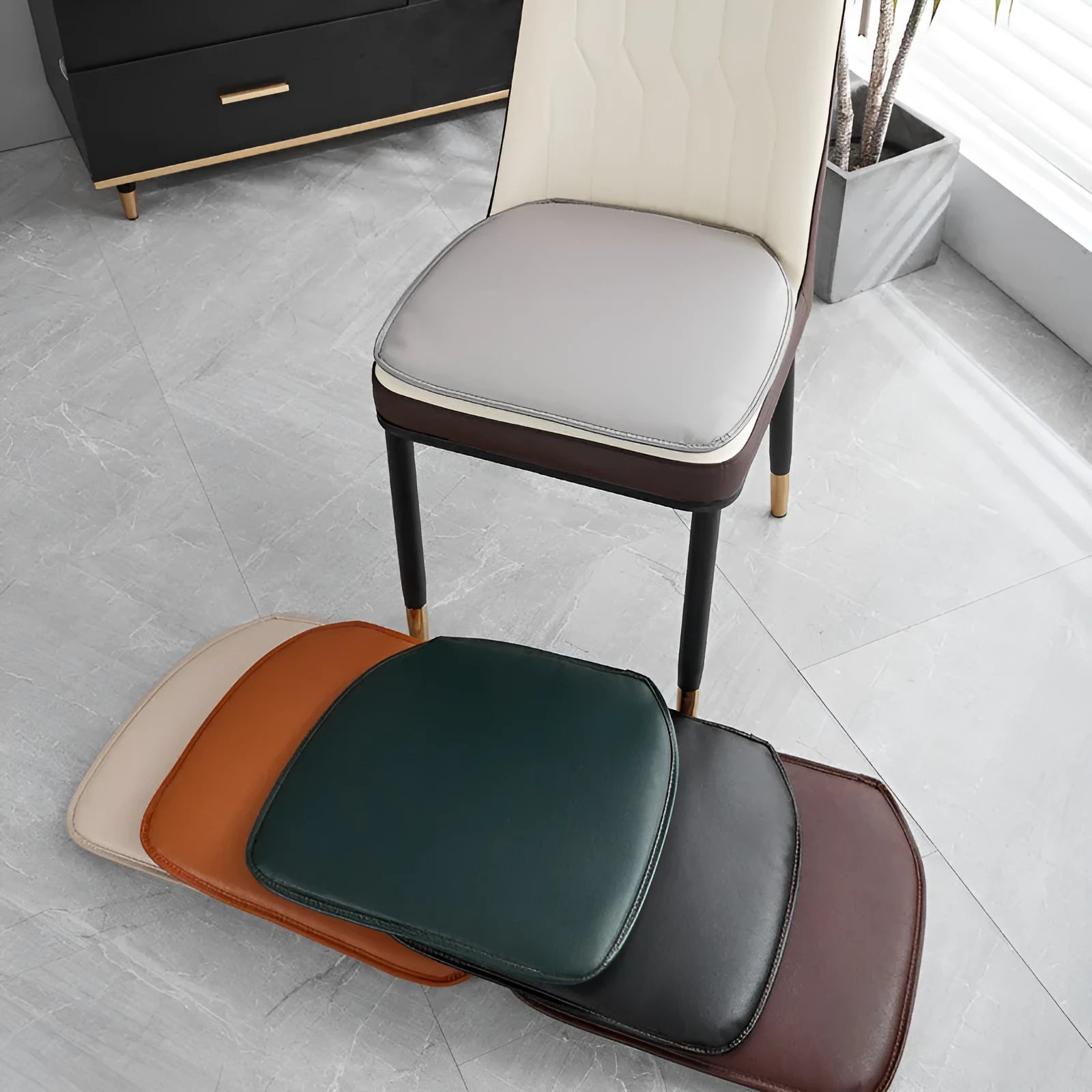 Solid colour leather horseshoe-shaped seat cushion with a non-slip base on a chair.