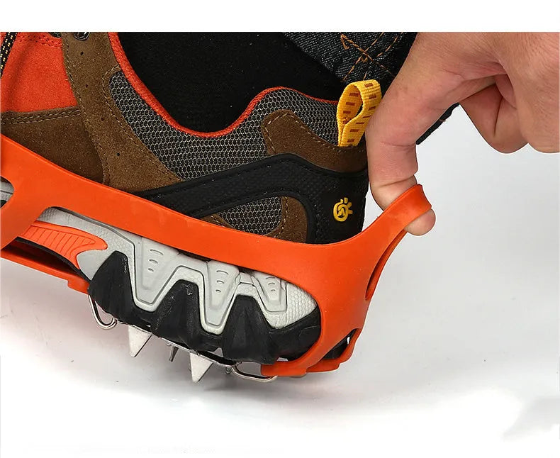 Reinforced non-slip crampons for shoes in black colour with large teeth, shown on a snowy surface