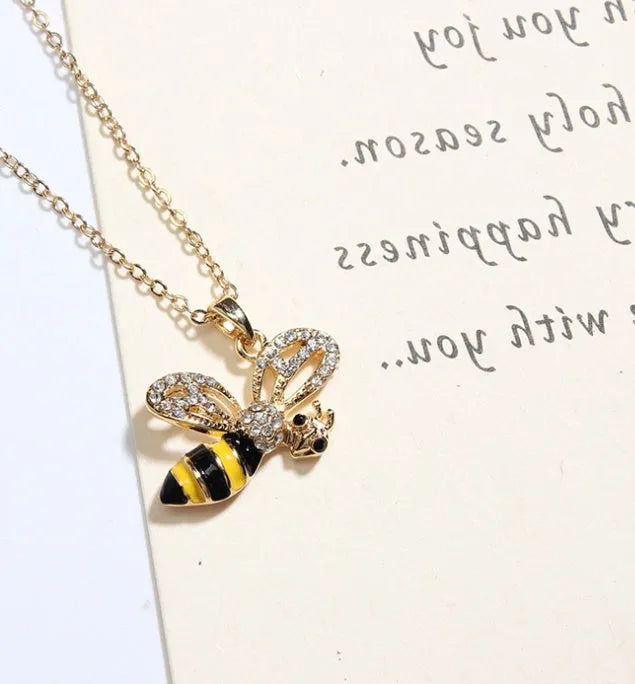 Cartoon bee drop pendant necklace with oil studded alloy finish on cross chain, yellow colour option, on white background