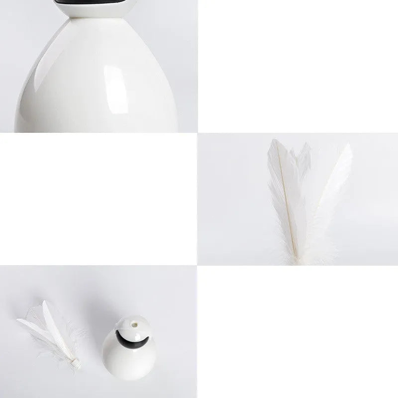ABS tumbler cat toy with feather attachment in white colour, on a flat surface