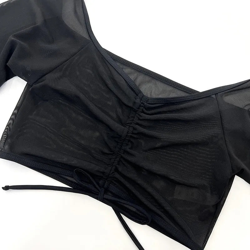 Black mesh four-piece women's bikini swimwear set with long sleeves on a hanger.