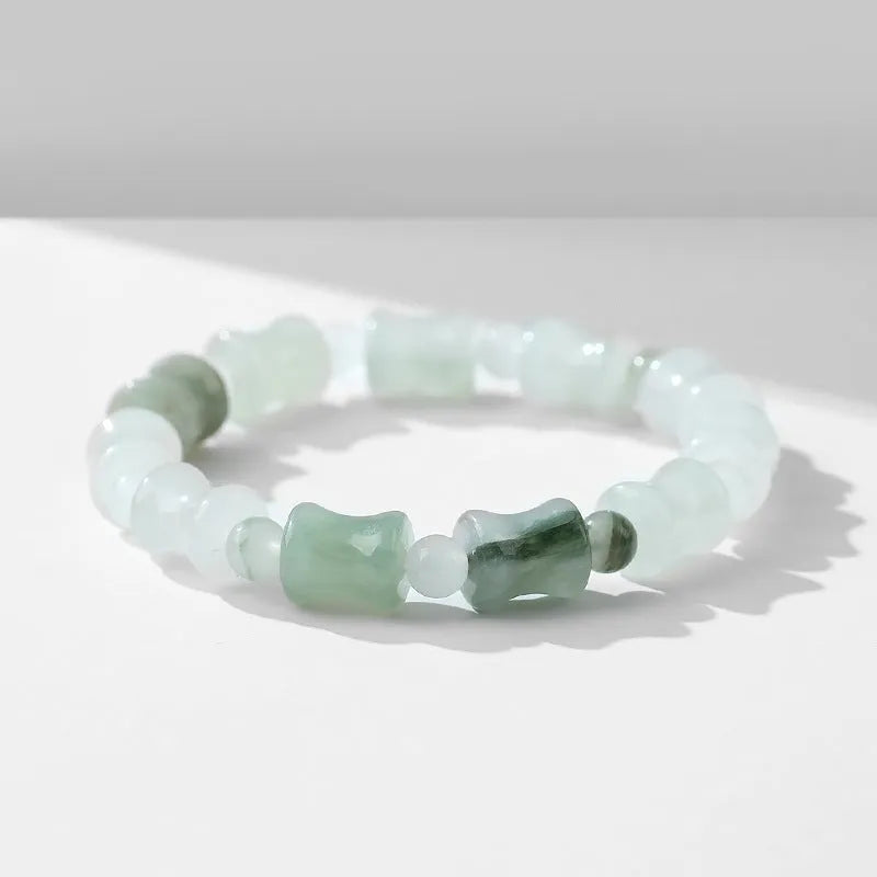 Simple beaded bracelet with a diamond-cut Tianshan Emerald chalcedony stone and coconut shell beads on an elastic band.
