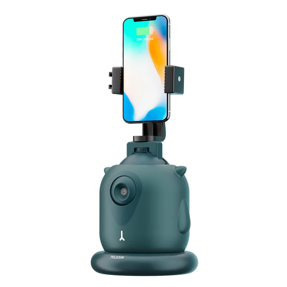 Dark green intelligent AI face tracking gimbal with 360-degree rotation on a desk.