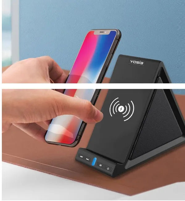 Black multifunctional Bluetooth speaker with integrated phone stand and wireless charging pad on a desk.