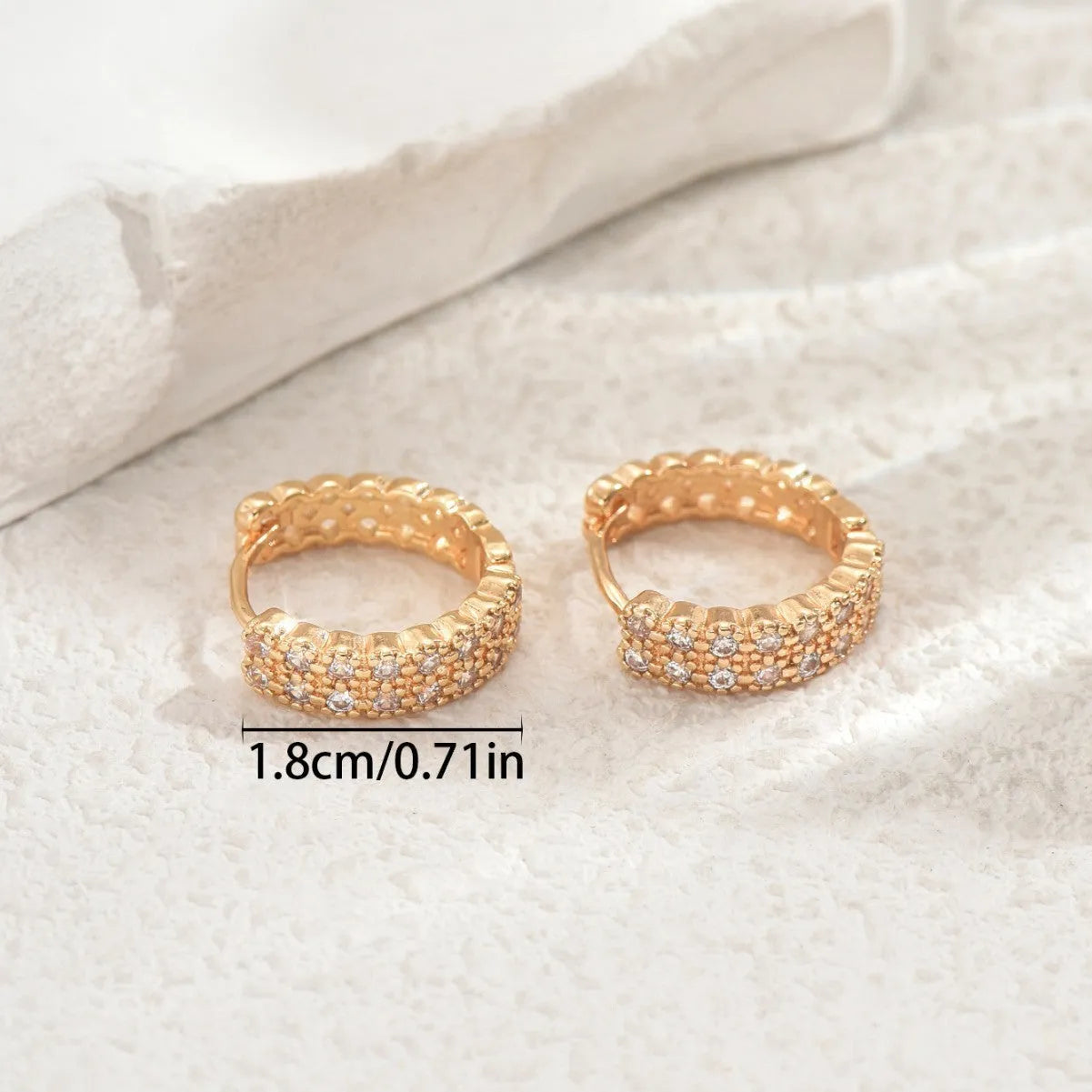 Polished copper geometry pattern ear studs with round base, central dot, and outer ring on a plain background.