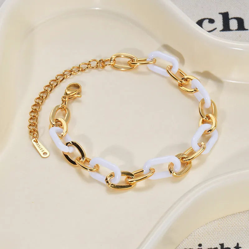 Close-up of a women's stainless steel bracelet with a double-layered heart pendant.