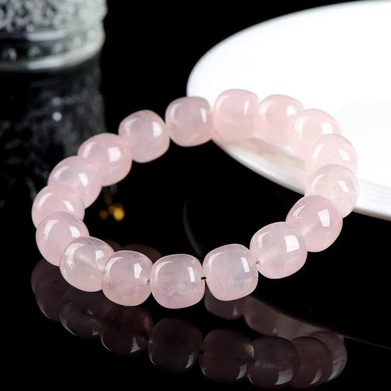 Pink crystal barrel bead bracelet with geometric beads on an elastic cord