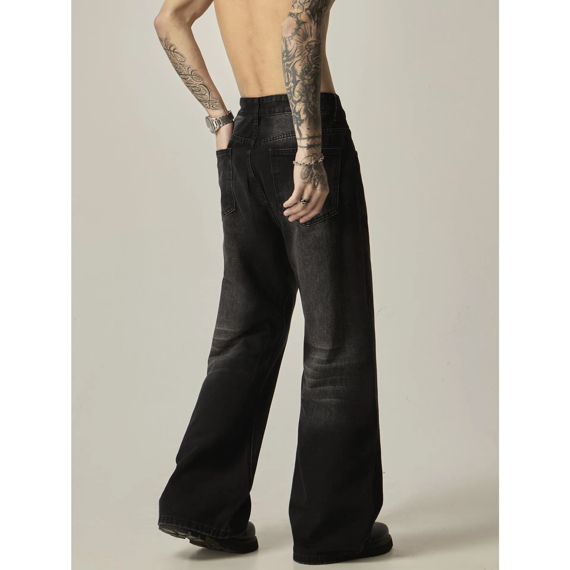Black straight-leg jeans with retro styling and loose fit on man