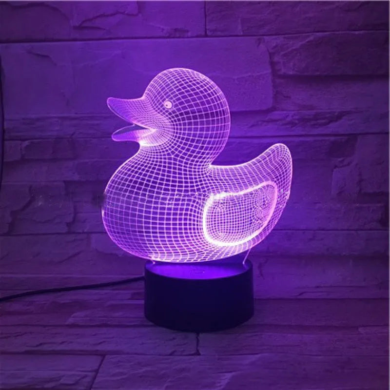 Yellow 3D duck-shaped LED night light with remote control on a table, showing soft multi-coloured glow.
