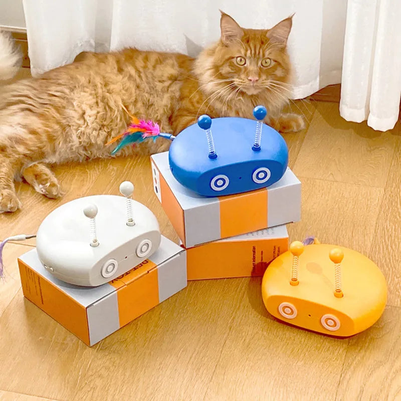 Blue rechargeable robot cat toy with laser pointer and feather attachments on grey floor