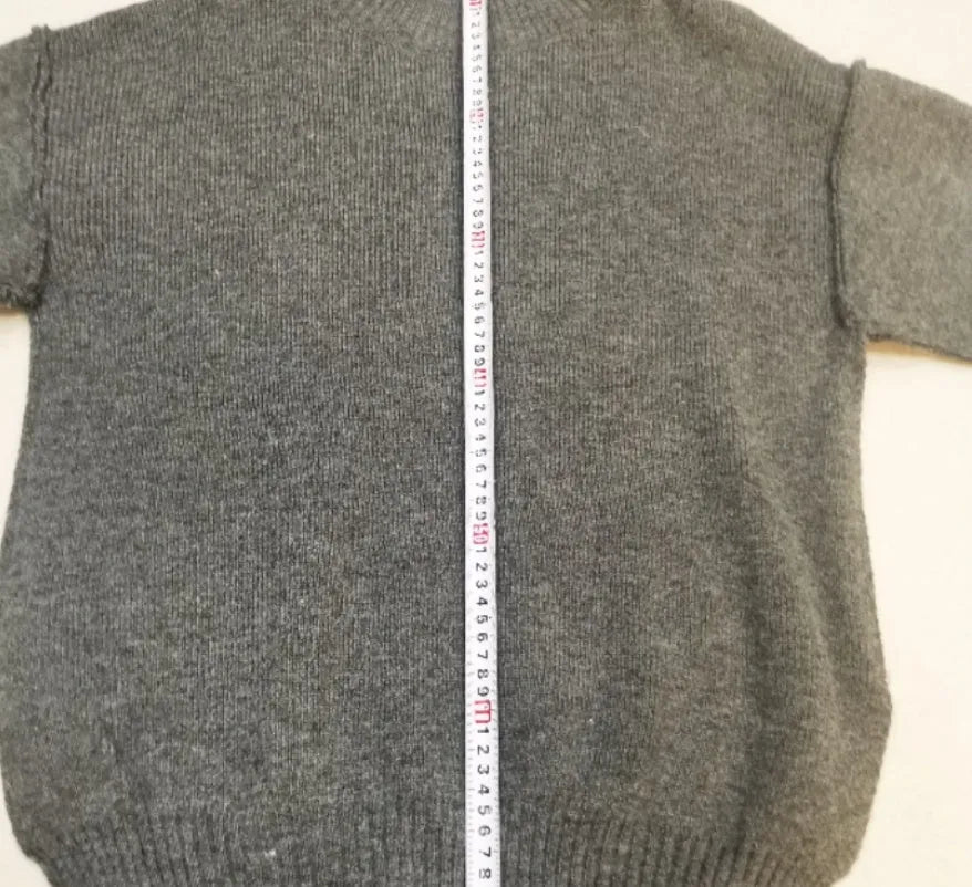 Women's dark grey acrylic knit co-ord set with side-slit sweater and matching trousers laid flat.