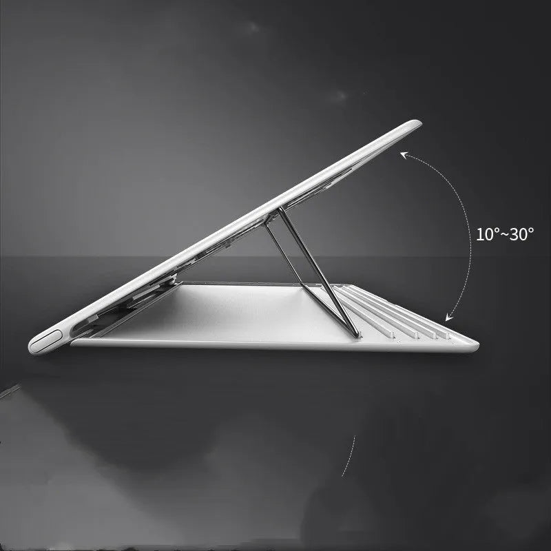 Portable black aluminium notebook stand folded flat next to a laptop