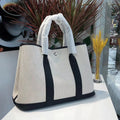 Women's canvas crossbody tote bag with leather trim in bucket shape showing internal organisation pockets.