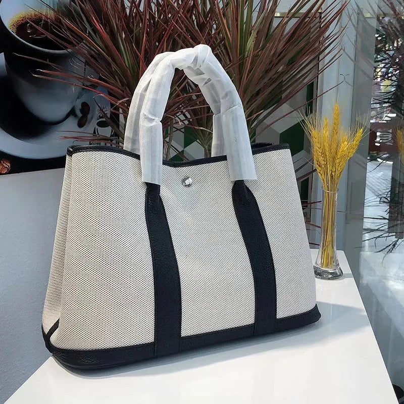Women's canvas crossbody tote bag with leather trim in bucket shape showing internal organisation pockets.