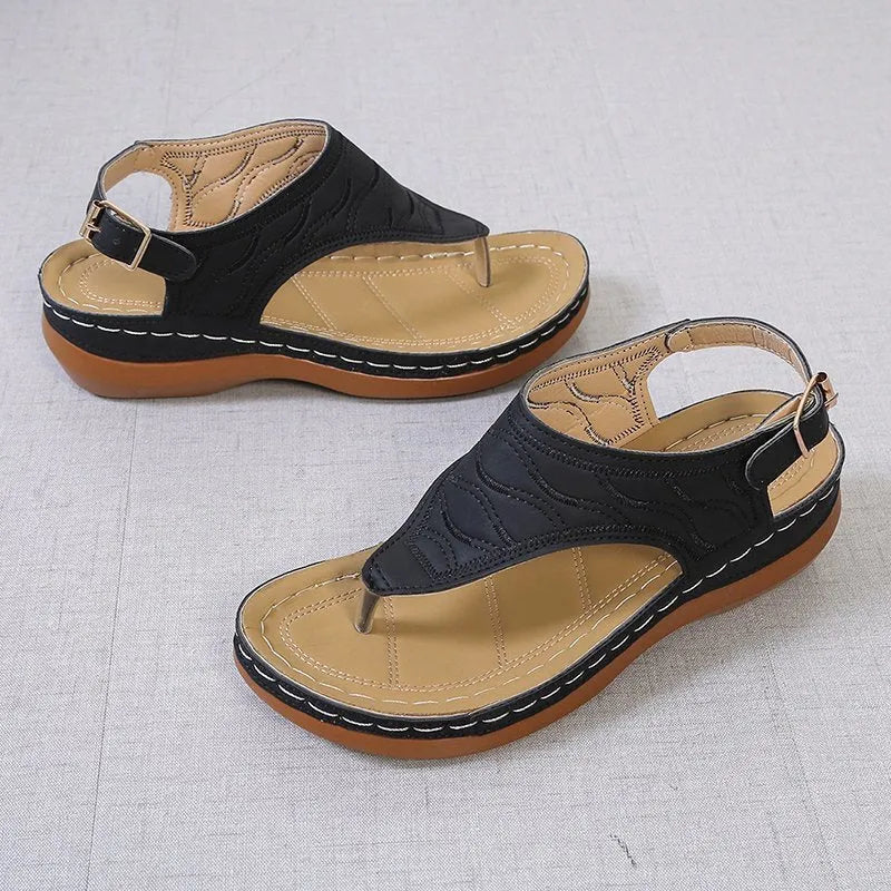 Women's casual wedge heel flip flop sandal in black with adjustable buckle strap.