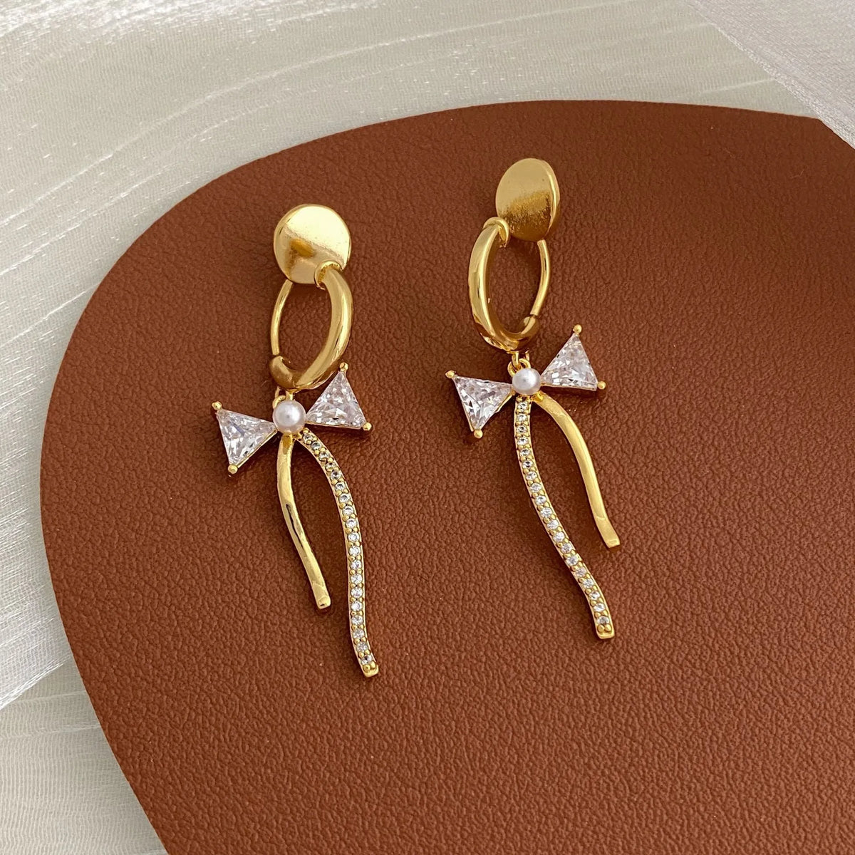 Asymmetric C-shaped copper earrings with inlaid zirconia stones, available as ear clips or ear studs for women.