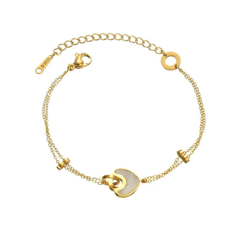 Close-up of a women's stainless steel bracelet with a double-layered heart pendant.