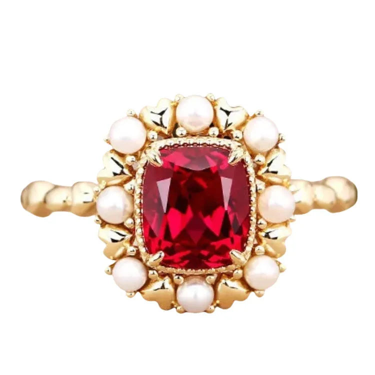 Gold electroplated ring with garnet red heart stone and geometric zircon setting.